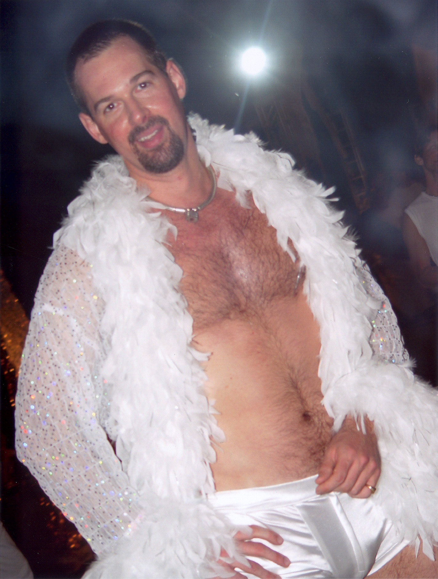 Alex years ago, wrapped in a white feather boa, laughing