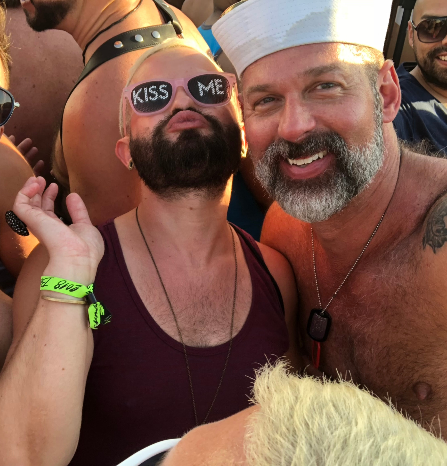 Alex grinning beside a friend in the golden late-afternoon light of a crowded party